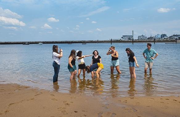 七个东北大学的学生站在海滩旁边的海里